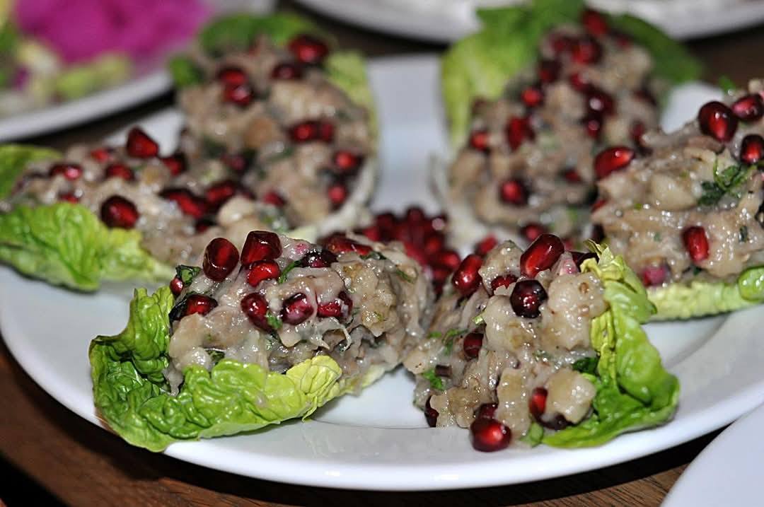 BABA GANOUSH z pieczonego bakłażana z tahini granatem na liściach sałaty